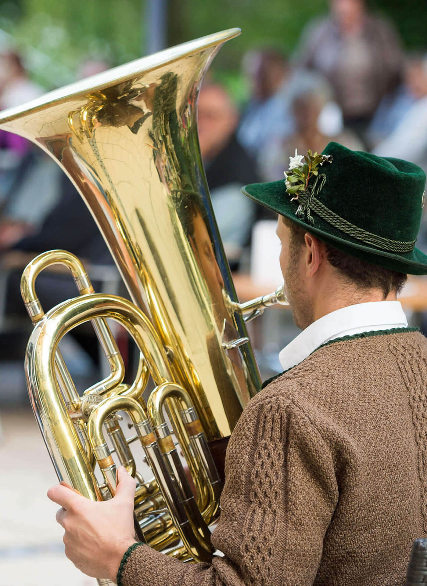 Volksmusikant in Tracht mit Tuba spielt im Brunnenhof Bad Aibling