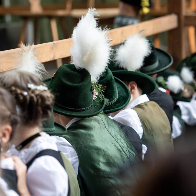 Kinder in bayerischer Tracht mit festlicher Kopfbedeckung aus Federn