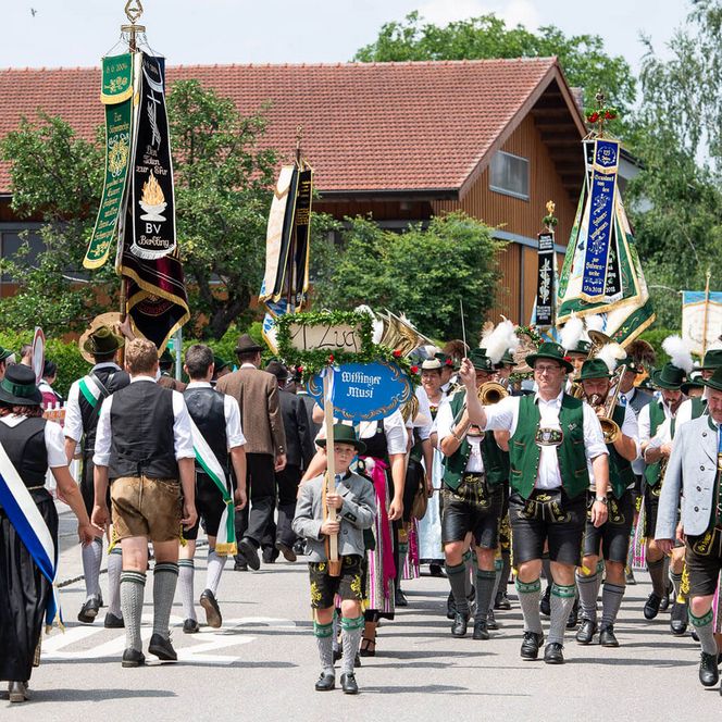 Festumzug mit Fahnen und traditionell gekleideten Teilnehmern