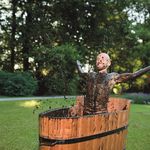 Mann baded fröhlich in Moorwanne auf Wiese