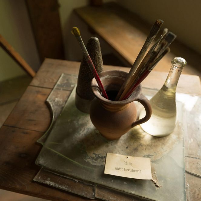 Historisches Malerwerkzeug mit Pinseln, Dokumenten und Mappe