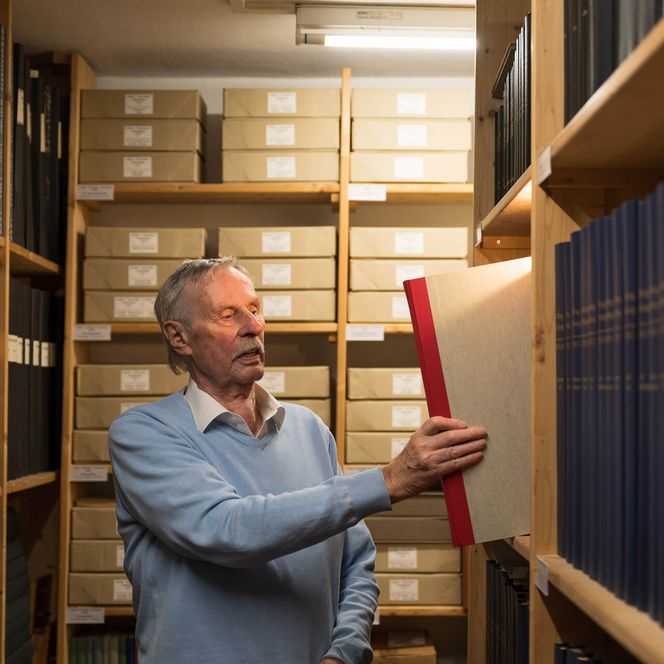 Manfred Schaulies holt Buch aus Regal im Archiv Heimatmuseum Bad Aibling