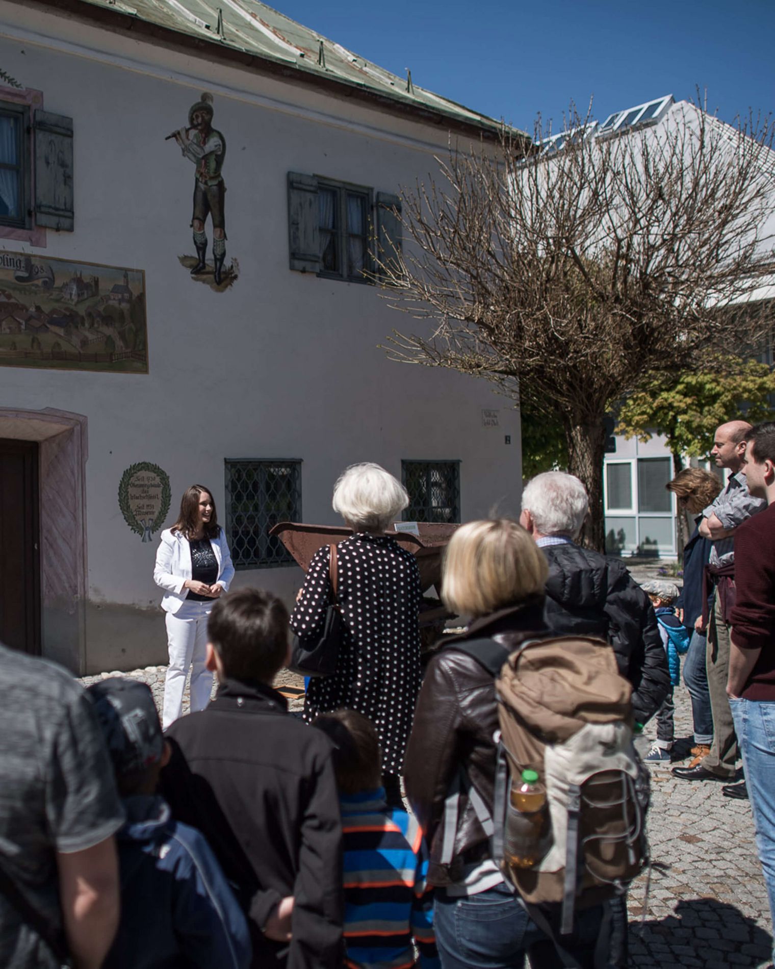 Stadtführerin erzählt einer Teilnehmergruppe vor dem Heimatmuseum geschichtliches